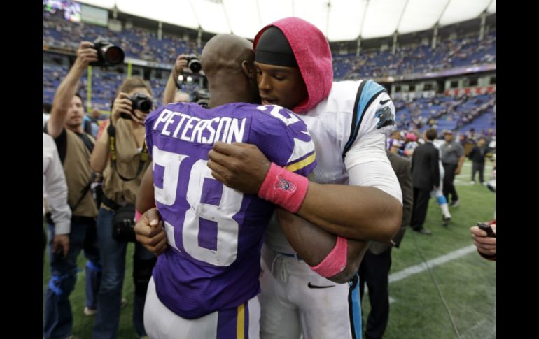 Cam Newton (D) muestra su apoyo a Peterson tras concluir el partido en el que las Panteras ganaron. AP /