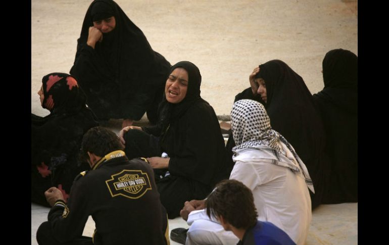 Unas mujeres lloran durante el funeral de una de las víctimas. AP /