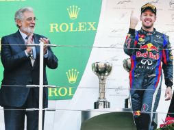 El tenor español Plácido Domingo aplaude al tricampeón del mundo, Sebastian Vettel, en la ceremonia de premiación. EFE /