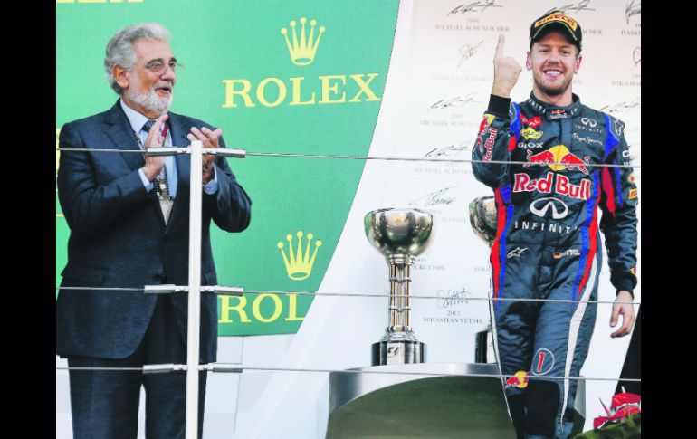 El tenor español Plácido Domingo aplaude al tricampeón del mundo, Sebastian Vettel, en la ceremonia de premiación. EFE /