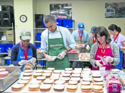 El presidente, Barack Obama  ayuda a empaquetar sándwiches junto a varios empleados federales. AFP /