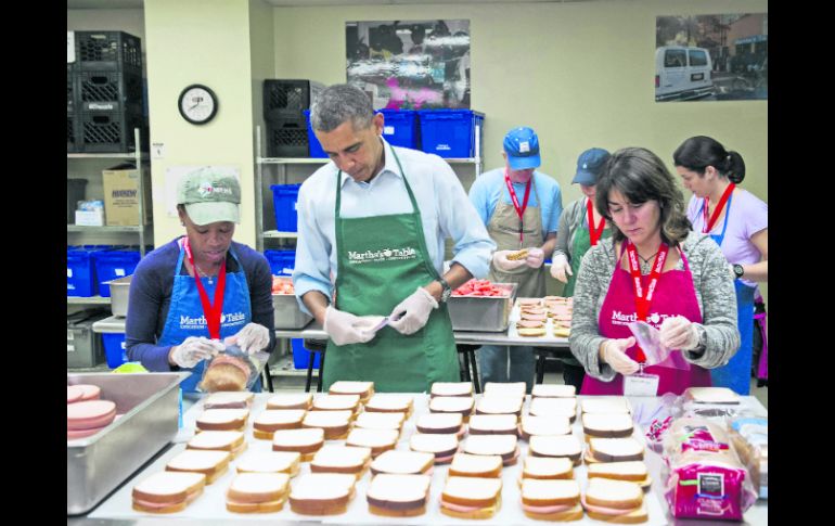 El presidente, Barack Obama  ayuda a empaquetar sándwiches junto a varios empleados federales. AFP /