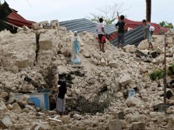 Lugareños se reúnen en los escombros de una de las iglesias destruidas por el terremoto. EFE /