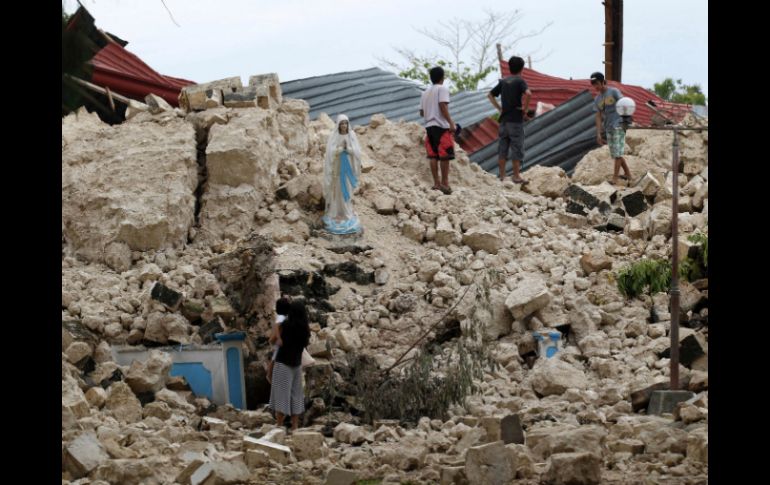 Lugareños se reúnen en los escombros de una de las iglesias destruidas por el terremoto. EFE /