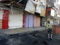 Un empleado del servicio municipal limpia una calle en el lugar donde se produjo un atentado. EFE /