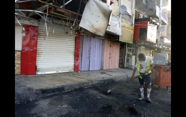 Un empleado del servicio municipal limpia una calle en el lugar donde se produjo un atentado. EFE /