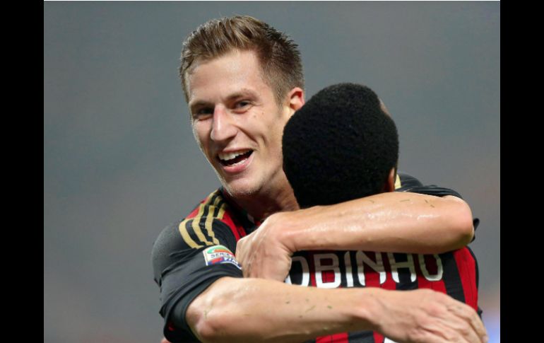 Valter Birsa celebra con Robinho la solitaria anotación de la victoria del Milan.  /