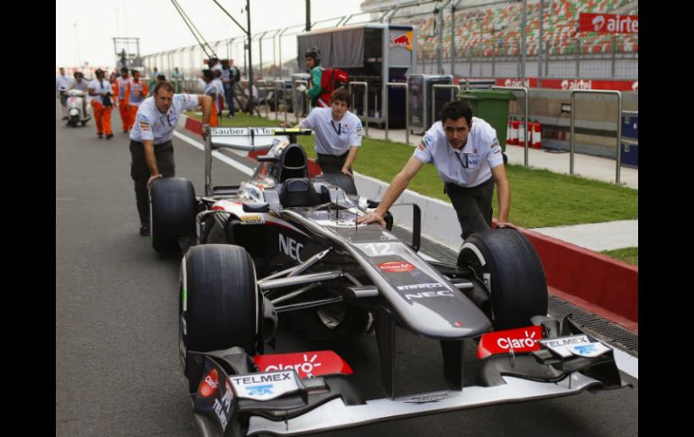 Mecánicos del equipo Sauber empujan el monoplaza de Esteban Gutiérrez por el circuito de Buddh en Noida. EFE /