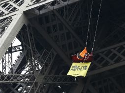 El hombre quedó suspendido con un cartel en el cual exigia la liberación de 30 activistas. AFP /