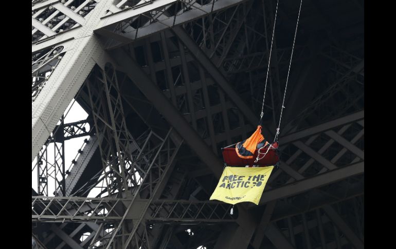 El hombre quedó suspendido con un cartel en el cual exigia la liberación de 30 activistas. AFP /