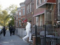 Un detective ingresa a la vivienda donde ocurrió el multihomicidio. AP /