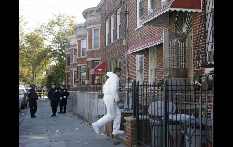 Un detective ingresa a la vivienda donde ocurrió el multihomicidio. AP /