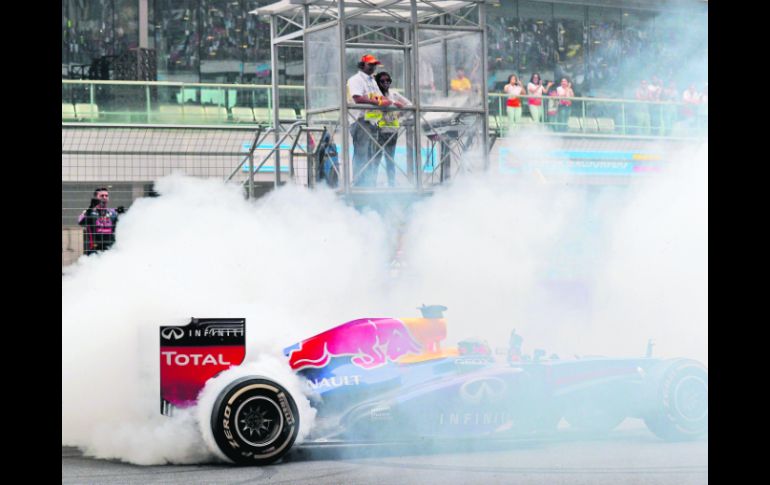 Sebastian Vettel festejó su triunfo y el título haciendo “donitas” quemando llanta.  /