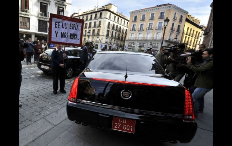 Un hombre sostiene una pancarta contra espionaje ante el coche del embajador de Estados Unidos en España. AFP /