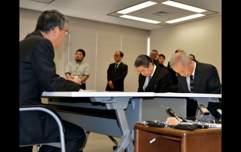 El directivo de TEPCO Naomi Hirose y su vicepresidente (D) se reunieron con Shunichi Tanaka, líder de la NRA . AFP /