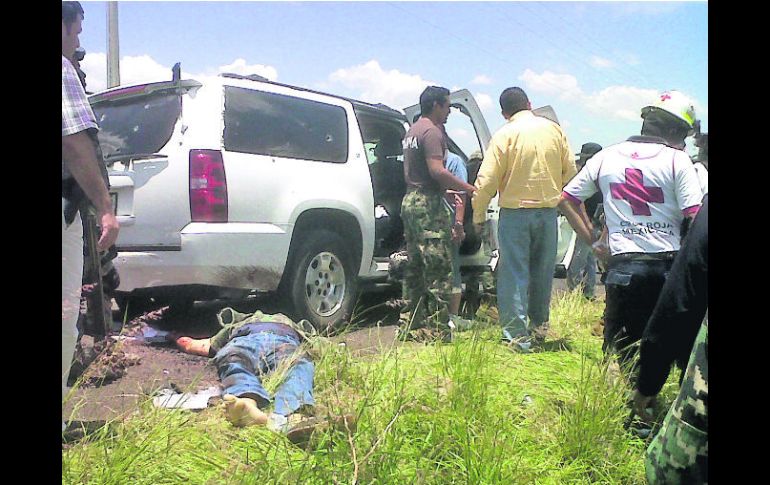 Escena común. Militares y socorristas inspeccionan una escena del crimen en Churintzio, Michoacán. AFP /