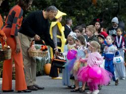 Barack Obama y Michelle vistieron de naranja, el color tradicional del Día de Brujas. AP /