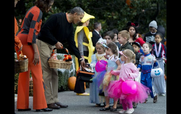 Barack Obama y Michelle vistieron de naranja, el color tradicional del Día de Brujas. AP /