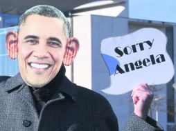 Infiltrados. Un activista disfrazado de Barack Obama sostiene una pancarta en la que se puede leer '' Lo siento, Ángela''. EFE /