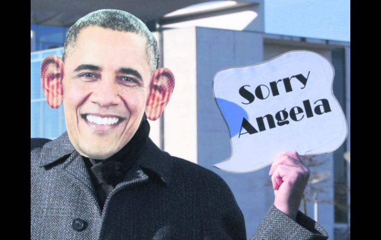 Infiltrados. Un activista disfrazado de Barack Obama sostiene una pancarta en la que se puede leer '' Lo siento, Ángela''. EFE /