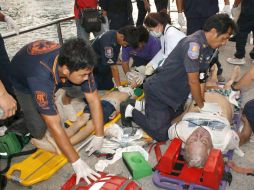 Rescatistas y médicos dan primeros auxilios pasajeros del ferry que naufragó. EFE /