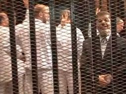 Morsi compareció ante el tribunal con un traje azul oscuro y sin corbata. Se negó a usar un uniforme de la prisión. AP /