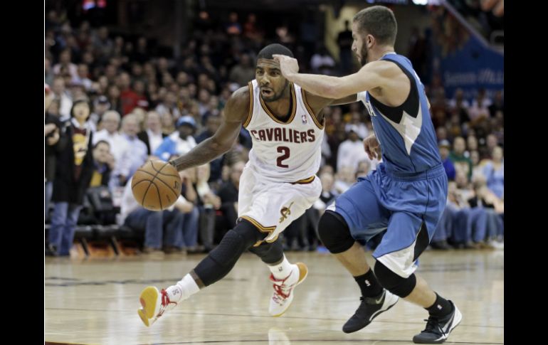 Kyrie Irving de Cavaliers, lleva la pelota ante JJ Barea de Timberwolves. AP /