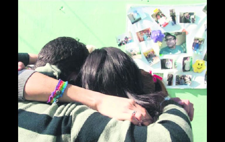 Familiares de las víctimas lloran frente a la casa donde ocurrió el asesinato. EFE /