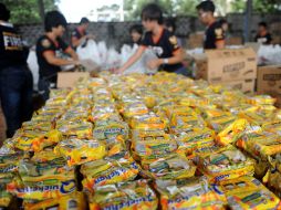 Voluntarios empacan comida que posteriormente entregarán los afectados por el tifón. AFP /