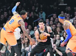 Danny Green (centro) protege la bola ante la marca de J.R. Smith y Carmelo Anthony. AP /