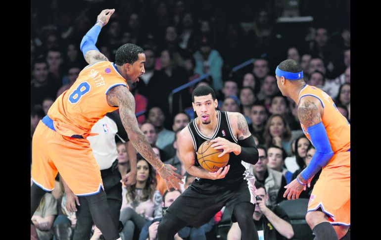 Danny Green (centro) protege la bola ante la marca de J.R. Smith y Carmelo Anthony. AP /