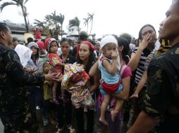 Miembros de la Fuerza Aérea filipina detienen a varios residentes durante el abordaje de un avión militar C-130. EFE /