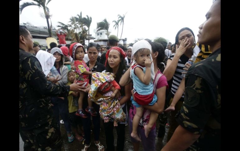 Miembros de la Fuerza Aérea filipina detienen a varios residentes durante el abordaje de un avión militar C-130. EFE /