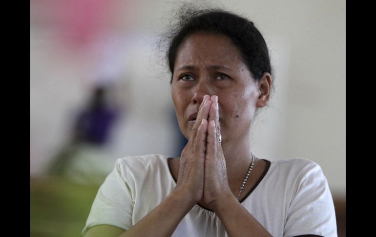 Una mujer reza en una iglesia devastada por el tifón en la localidad de Tacloban. EFE /