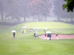 Uno de los grupos llega al green del hoyo 1 bajo la lluvia.  /