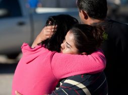 Dos mujeres se abrazan y lloran ante la noticia de las muertes. AFP /