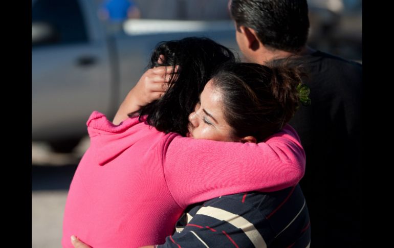 Dos mujeres se abrazan y lloran ante la noticia de las muertes. AFP /