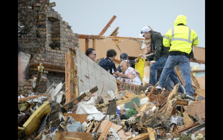 Equipos de rescate ayudan a un residente herido en Illinois por el tornado. AP /