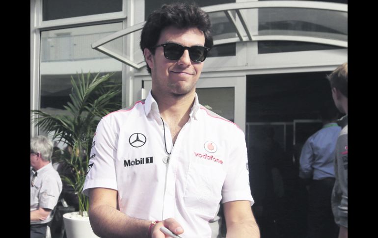 Sergio Pérez firma una gorra a un aficionado, durante el GP de Estados Unidos, el penúltimo que correrá con McLaren. AP /