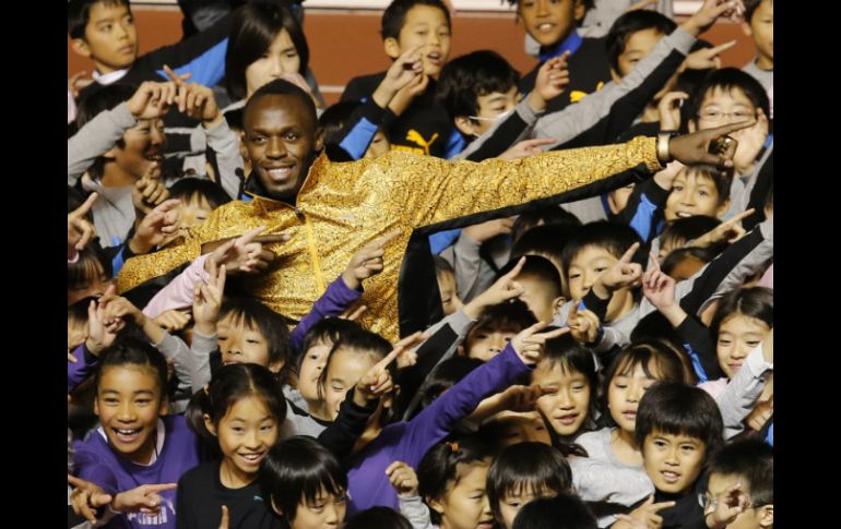 El multicampeón Usain Bolt se reúne con niños japoneses en Tokio. AP /