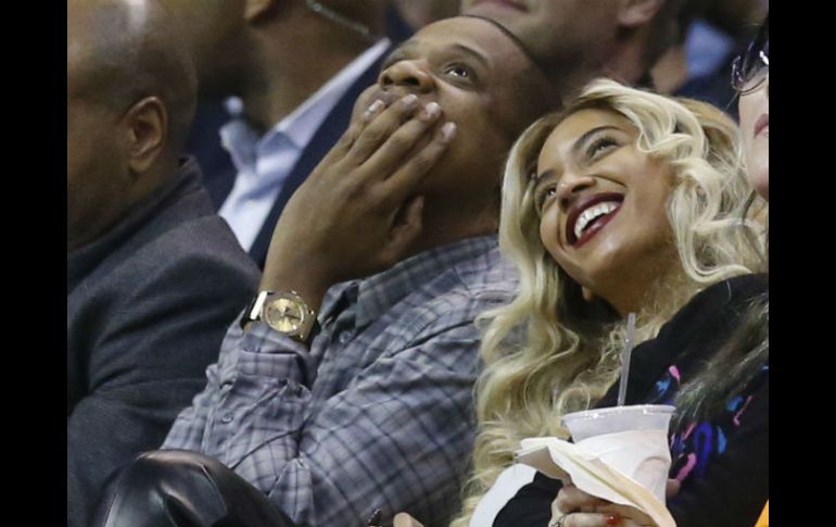 Acompañada de Jay Z, la cantante presume su nueva imagen durante un partido de la NBA. AP /