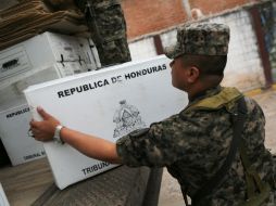 Un soldado hondureño descarga desde un camión una caja con las papeletas en Tegucigalpa. AFP /