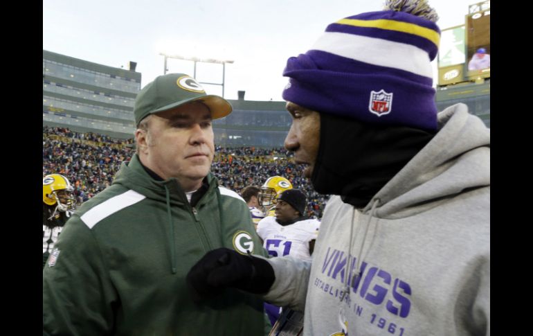 Los entrenadores Mike McCarthy (I) y Leslie Frazier se saludan luego de que sus equipos empataran en el emparrillado. AP /