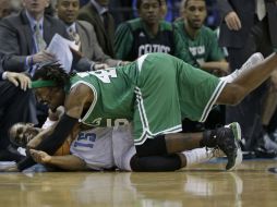 El jugador de los Celtics Gerald Wallace cae sobre otro de los Bobcats durante el partido. AP /