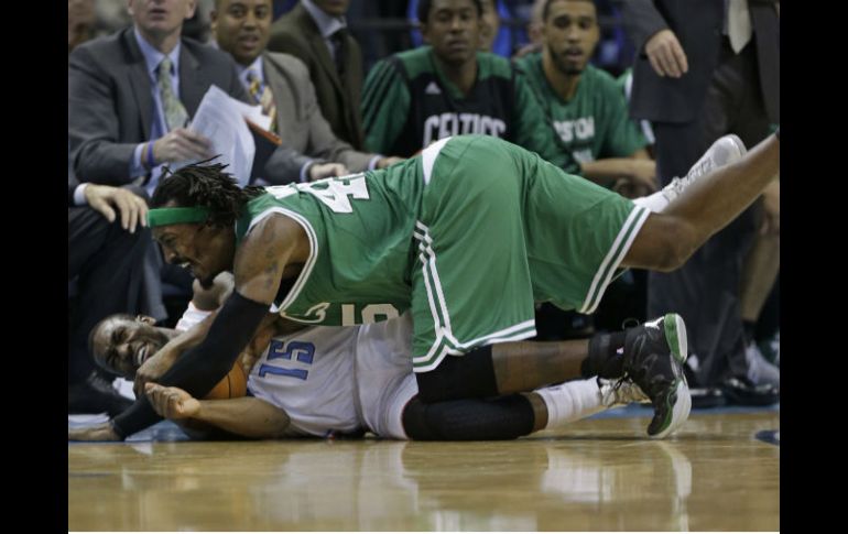 El jugador de los Celtics Gerald Wallace cae sobre otro de los Bobcats durante el partido. AP /