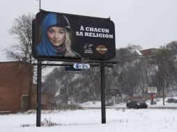 Los páneles publicitarios tienen un símbolo católico y uno musulmán; dicen a cada uno su religión. AFP /