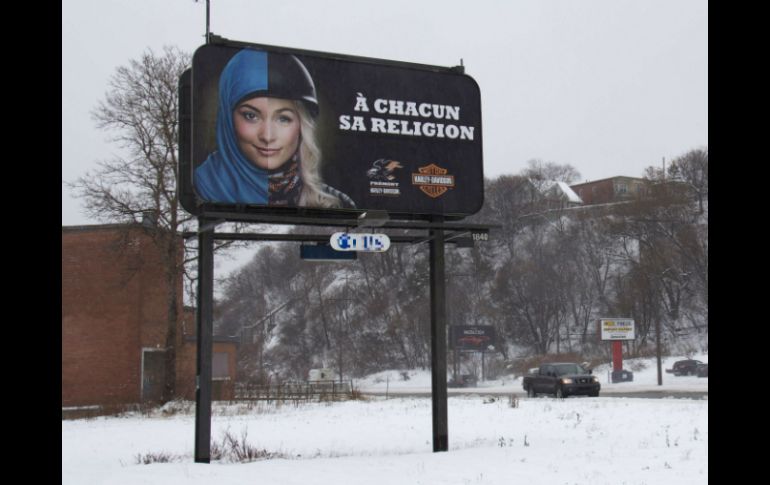 Los páneles publicitarios tienen un símbolo católico y uno musulmán; dicen a cada uno su religión. AFP /