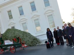 Michelle Obama y sus hijas acogieron el árbol navideño que decorará el Salón Azul de la Casa Blanca. AFP /