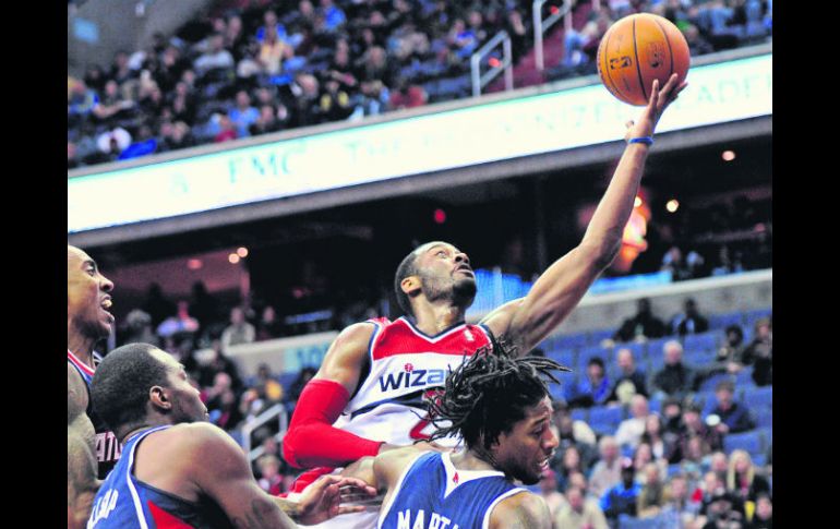 John Wall anota para los Wizards de Washington ante la marca de Paul Millsap y Cartier Martin, de los Hawks. AP /