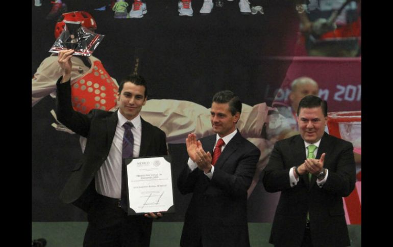 Recibe el premio Luis Rivera (i), medallista de bronce de salto de longitud en los Mundiales de Atletismo. NTX /